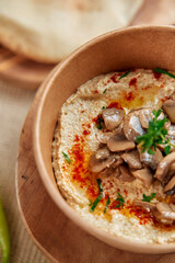 Creamy Hummus Made from Chickpeas and Topped with Sautéed Mushrooms and Spices Served in a Stylish Bowl for a Delicious Appetizer or Snack