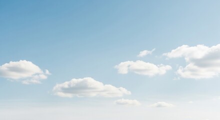 Expansive clear blue sky with scattered fluffy white cumulus clouds on a bright sunny day.