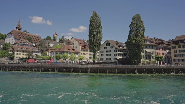 Reuss River Waterfront with Historic Houses and Musegg Wall Towers in Lucerne.Captured on July 17, 2025