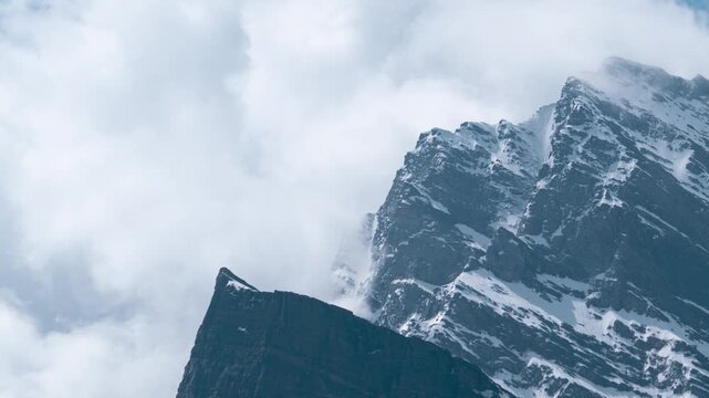 4K time lapse shot of storm clouds and snowy Himalayan mountain peak during the monsoon season as seen from Khangsar village in Lahaul Valley, Himachal Pradesh, India. Dark monsoon clouds in mountains