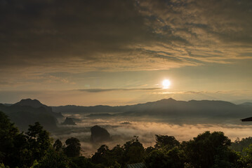 Dramatic sunset over mountain landscape. Beautiful landscape foggy hills twilight time. Blue golden sky sunrise dramatic beautiful landscape mountain. Dawn sky gold dusk time cloudscape with sunlight