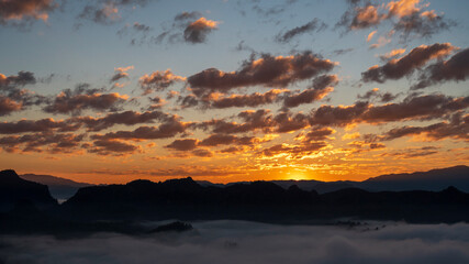 Sunset mountain range beautiful landscape mist foggy sunrise beam. Golden sky Mountain landscape foggy windy mountain. Amazing Landscape cloud sky on sunrise. Countryside gold sunlight heaven scene