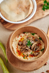 Deliciously Creamy Hummus Topped with Savory Mushrooms and Fresh Herbs Served with Warm Flatbread...