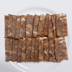 A close-up of a plate of pyeonyuk, a savory and wholesome Korean pressed pork dish.