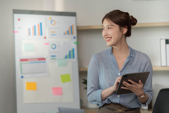Professional woman analyzing data with tablet in modern office - Powered by Adobe