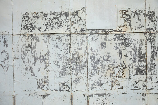 Weathered wall shows signs of age with peeling paint, and texture creates an abstract background.