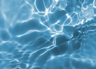Abstract blurred shades of blue water background. Light and shadow ripples or splashes surface of water texture. Water waves with shining and reflection pattern photography for​ design artwork.