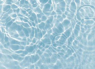 Abstract blurred shades of blue water background. Light and shadow ripples or splashes surface of water texture. Water waves with shining and reflection pattern photography for​ design artwork.