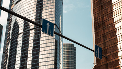 sign with the symbol up on the background of the skyscrapers of the business district of a modern city