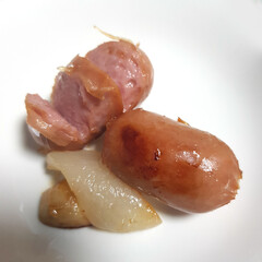A close-up of a plate of fried Vienna sausages, a simple and savory side dish or meal.