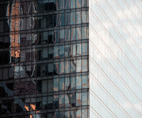 mirrored windows of the facade of an office building with blue panels