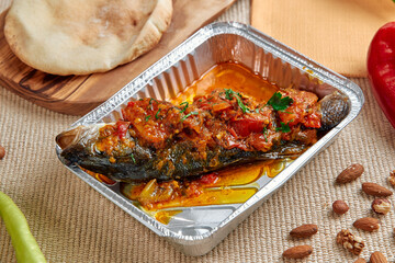 Deliciously Prepared Grilled Fish Garnished with Spicy Tomato Sauce and Served with Fresh Ingredients, Perfect for a Flavorful Meal Experience