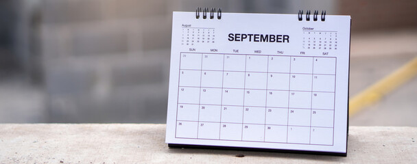 2025 Calendar desk place on table. Desktop Calender for Planner to plan agenda, timetable, appointment, organization, management each date, month, and year on wooden office table-banner image.