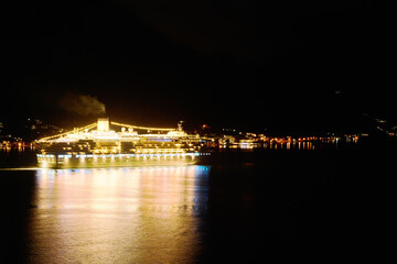 Fototapeta premium Nighttime cruise ship with glowing lights
