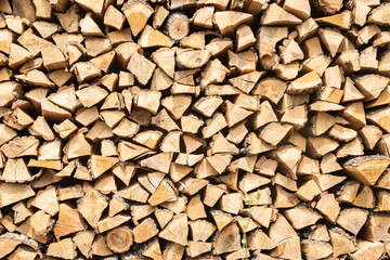 Pile of chopped firewood prepared for winter. Natural wooden background.