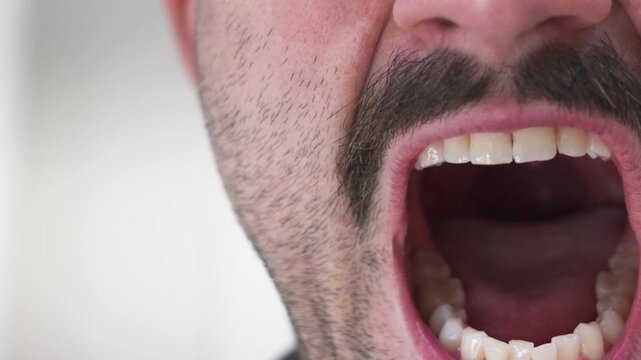 A man opens his mouth to scream in a speed ramped clip.