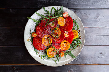Simple Italian Salad with Tomatoes and Arugula on black wooden background, Italian Food