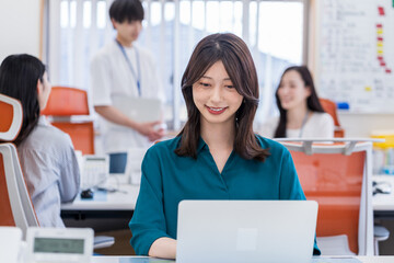 オフィスで働く若い女性。
