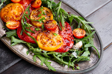 Simple Italian Salad with Tomatoes and Arugula on wooden background close up, Italian Food