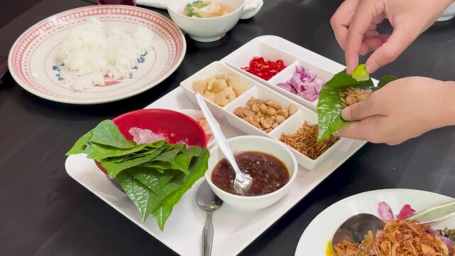 Preparing Miang Kham Savory Leaf Wraps at Dining Table