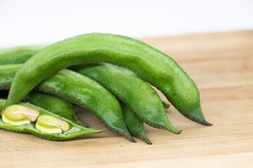 Close up of a wooden crate filled with broad beans. Broad bean Raw.