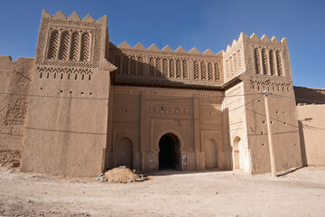Rissani - Ksar Ouled Abdelhalim, entrance to the fortified village, two towers and upper sections decorated  in clay bricks. Morocco, Erg Chebbi Sahara desert, North Africa

