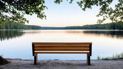 Obraz premium Serene wooden bench facing tranquil lake surrounded by lush trees under clear sky