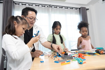 Focus diverse girls assembling colorful robot parts during STEM lesson, developing engineering skills, creativity, and problem-solving abilities in an engaging and collaborative learning environment