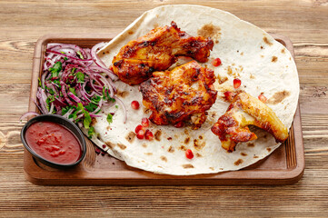 chicken shashlik on pita bread with onions and sauce