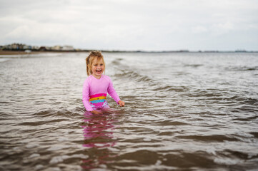 Little girl playing at the northern english seaside, cloudy day