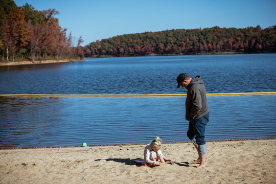 Dad and daughter playing on sand beach at Missouri state park