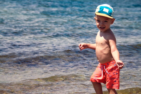 Happy child smiling at camera on seashore