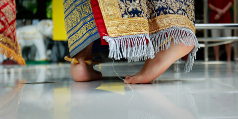 close up of feet of a thai dancer in traditional costume during ceremony