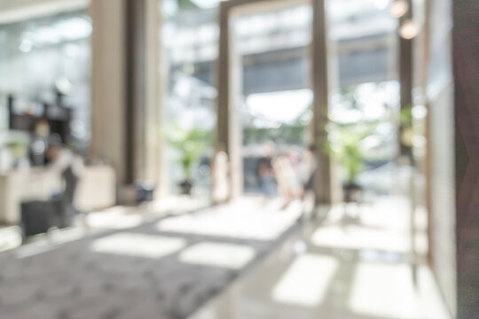 Hotel or office building lobby blur background interior view toward reception hall, modern luxury white room space with blurry corridor and building glass wall window