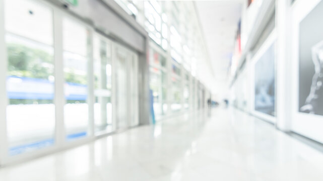Office business building blur background of white empty room inside lobby hall interior, medical clinic hallway, or airport terminal corridor passage way with blurry light from glass wall window