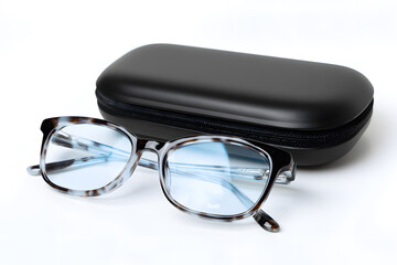 Black glasses case with folded eyeglasses on neutral background. Minimalist optical accessory photo for vision care, eyewear