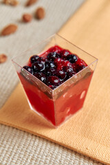 Colorful Dessert with Layers of Jelly and Berries Served in a Clear Cup Perfect for Refreshing Summer Treats on a Cozy Table Setting