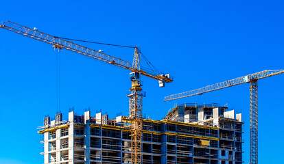 construction cranes are building a house
