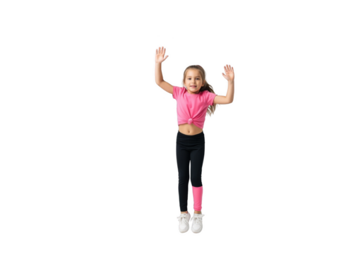 A young girl in pink top and leggings jumps with arms raised, smiling against a white background.