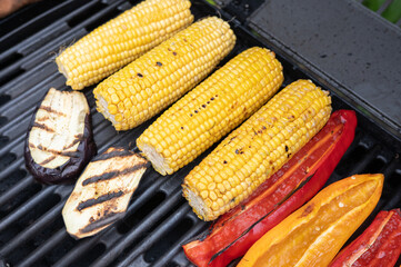 Grilled corn and vegetables on barbecue grill with eggplant and bell peppers