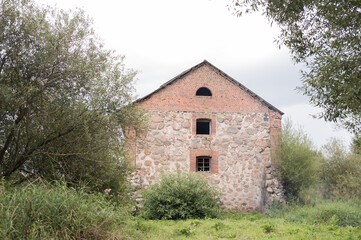 Old stone barn surrounded by lush greenery in tranquil rural setting