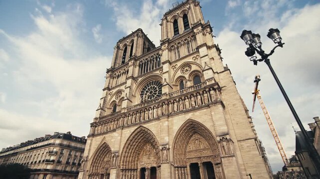 Notre Dame de Paris in the capital of France. Beautiful architecture of the ancient cathedral in the tourist streets of the European city.