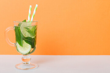 Mojito summer refreshing cocktail with ice and mint. mojito cocktail with lime, lemon and mint in a tall glass with a stick