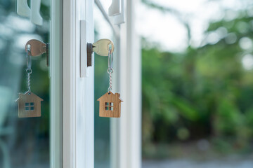 Landlord key for unlocking house is plugged into the door. Second hand house for rent and sale. keychain is blowing in the wind. mortgage for new home, buy, sell, renovate, investment, owner, estate