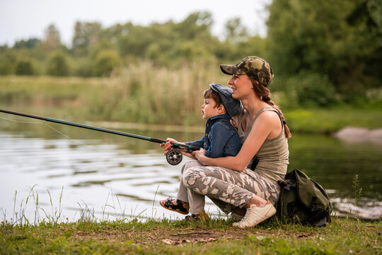 young mother fishing on the lake with her little son