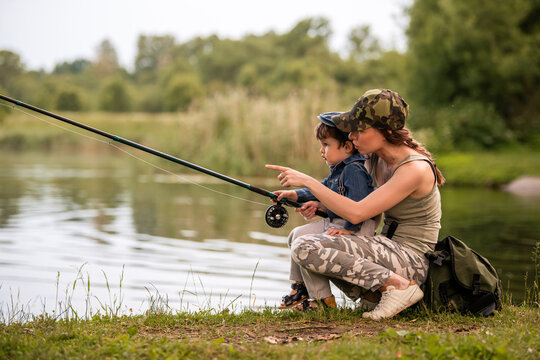 young mother fishing on the lake with her little son