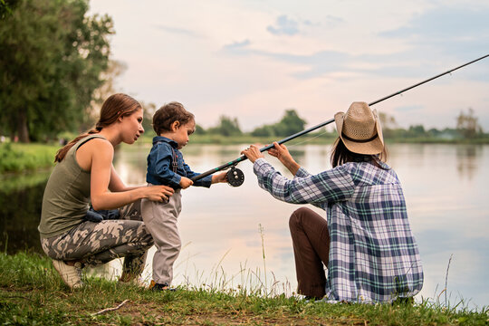 young mother, toddler son and grandmother fishing on the lake
