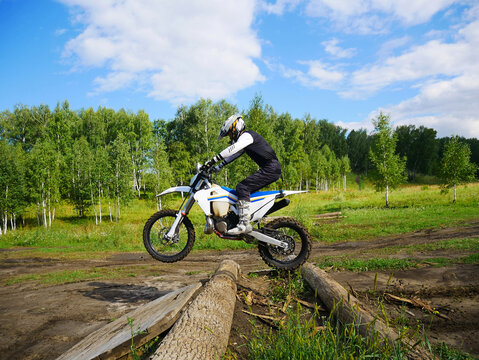 Motocross Rider Conquering Logs on Dirt Track