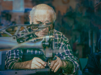 Elderly shoemaker at sewing machine in Cambridge workshop