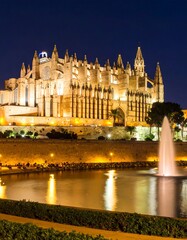 Fototapeta premium Illuminated cathedral at night, reflecting in water